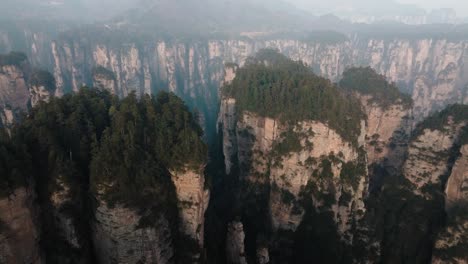 aerial panorama of dense forest atop massive sandstone formations in zhangjiajie national park surrounded by deep cliffs and valleys