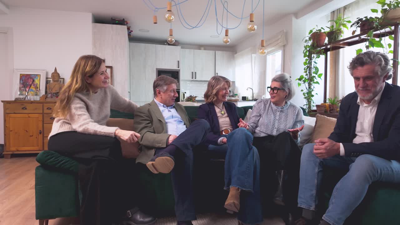 Venner, der snakker og griner i en sofa i en moderne stue
