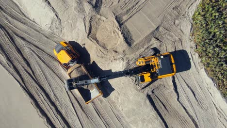 Toma-De-Drones-De-4k-De-Excavadoras-Trabajando-En-La-Playa-Cerca-Del-Agua-Del-Océano-Con-Vegetación-Tropical-Cerca