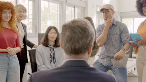 boss talking to workers in a meeting in a coworking