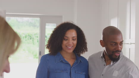 couple viewing potential new home with female realtor