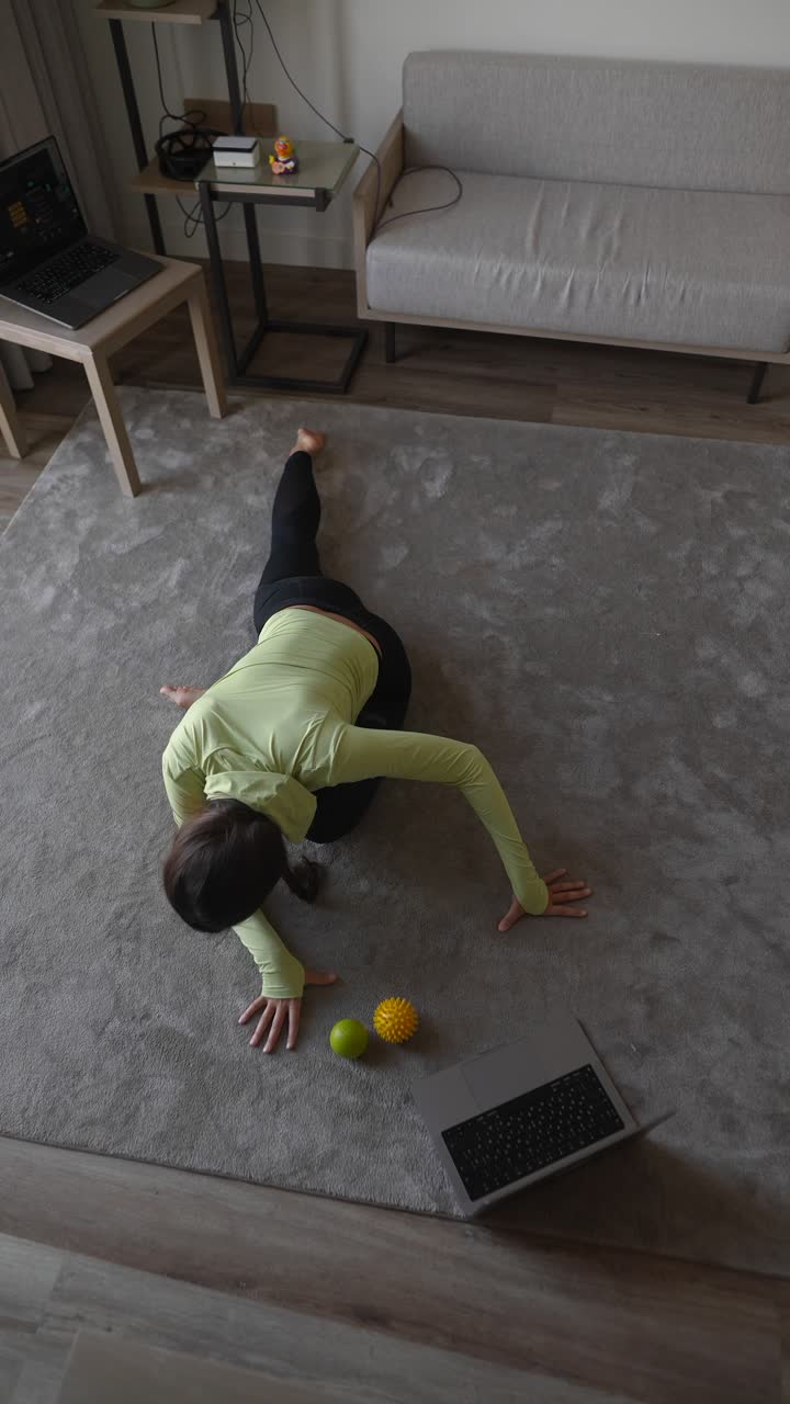 mujer estirándose en casa durante una clase de fitness en línea