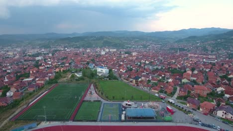 Sports-Field-Next-To-Amusement-Park-in-The-City-Novi-Pazar-in-Serbia-Europe-on-a-Cloudy-Afternoon,-Aerial-Forward