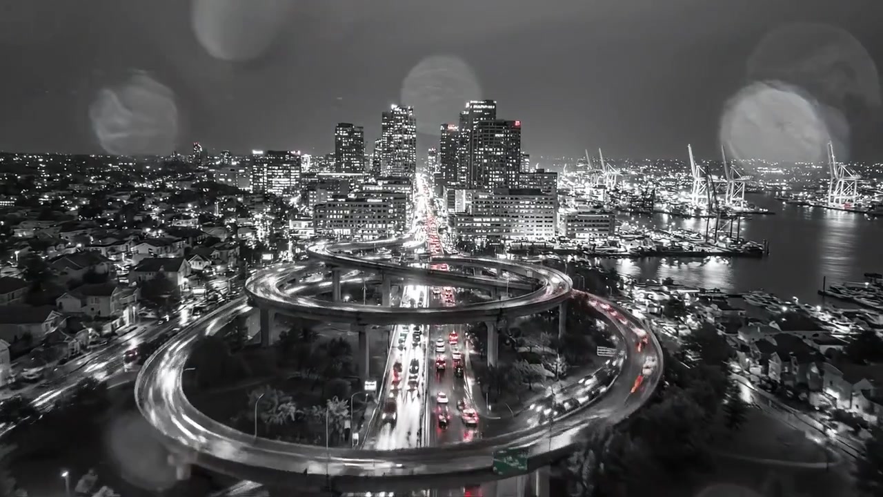Escena urbana nocturna con ciclistas y tráfico bajo un paso elevado de autopista, capturando las vibrantes luces de la ciudad y el movimiento en una estética en blanco y negro.