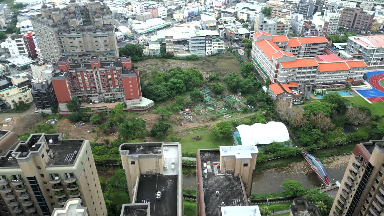 Aerial top down of green landscape between School and low class residential towers in Taiwan. Luzhu Districrt, Taoyuan City.