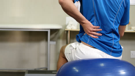 man sitting on exercise ball