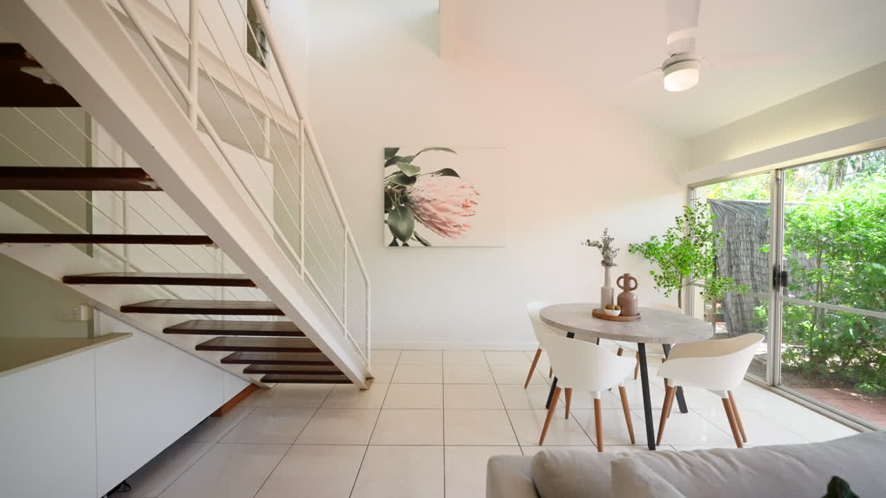 sala de estar interior de casa moderna elevada urbana con sofá y cocina en escena, dolly más allá de la escalera abierta