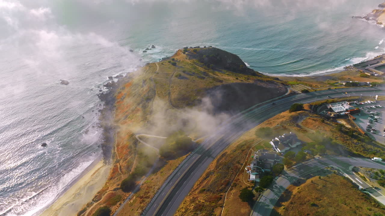 Road passing through the rocks of Montara, California, USA. Drone descending over the hill on the State Beach of Montara.