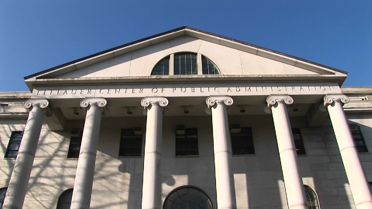 panoramización hacia abajo desde la cima del centro littauer de harvard para el edificio de la administración pública hasta los escalones que conducen a su entrada