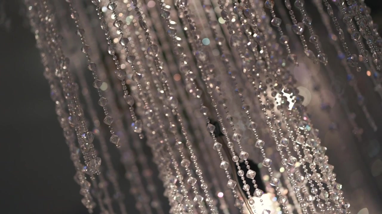 Primo piano di pendenti di lampadario di cristallo scintillanti con morbidi effetti bokeh in luce calda
