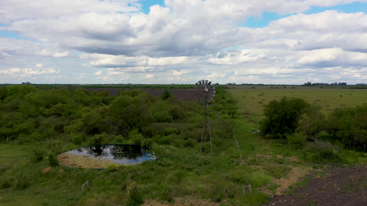la bomba de agua del molino de viento gira en la naturaleza verde en argentina, se hunde la antena