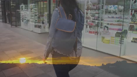 Animation-of-spots-of-light-over-caucasian-woman-walking-in-city-street