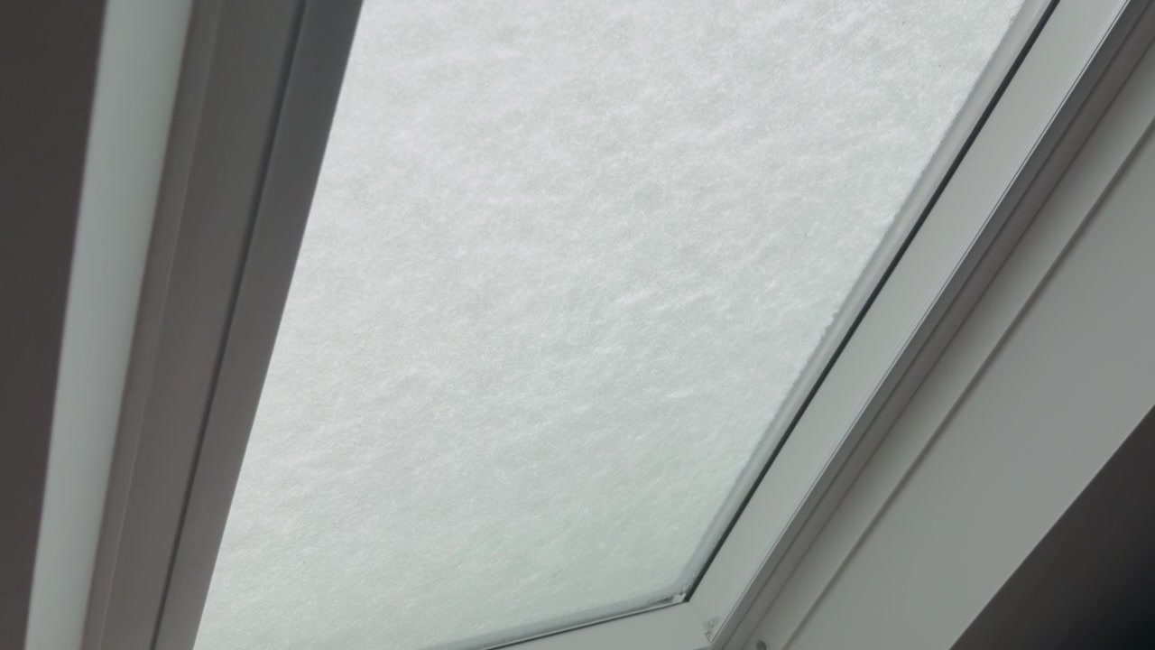 Lucernario coperto di neve visto dall'interno, che crea un'atmosfera invernale serena con luce soffusa.