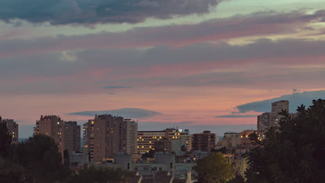 Timelapse-De-Zoom-Lento-De-Nubes-Rojas-Y-Rosas-Moviéndose-Rápido-Durante-La-Puesta-De-Sol-Sobre-Una-Vista-De-Edificios-De-Apartamentos-Y-Hoteles-En-Costa-Del-Sol,-España