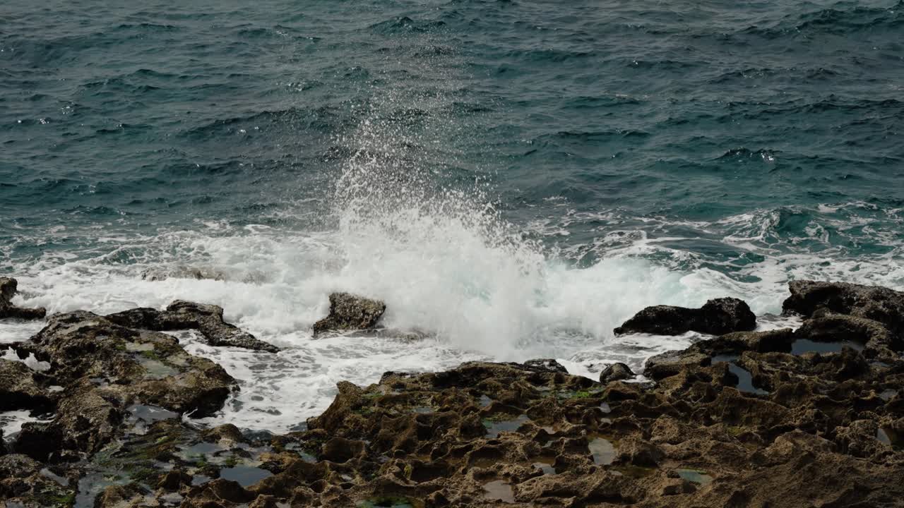 Waves break against rugged rocks on Tangier’s Atlantic shoreline, spraying into the air