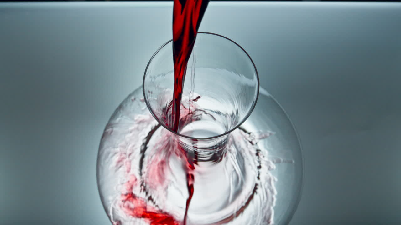 Decanter rose wine pouring super slow motion. Red drink filling clean glassware