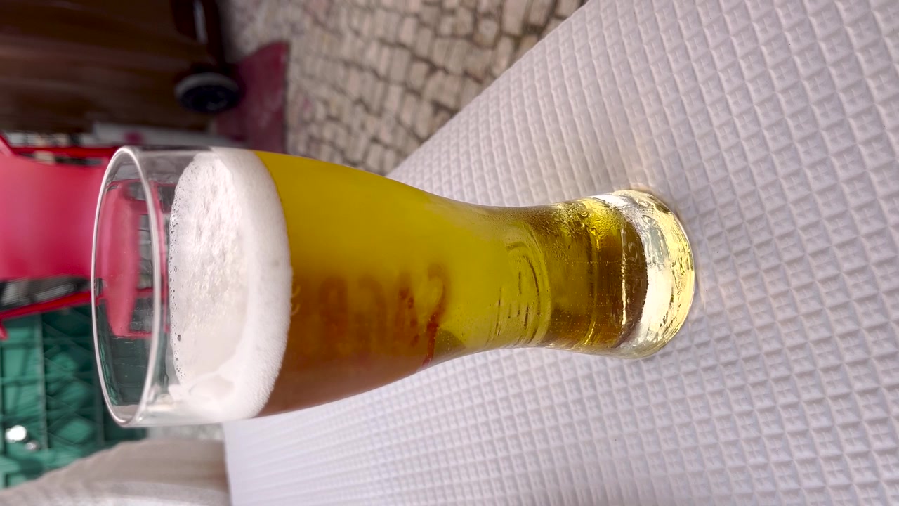 Vista di un bicchiere di birra su un tavolo. Formato verticale per i social media