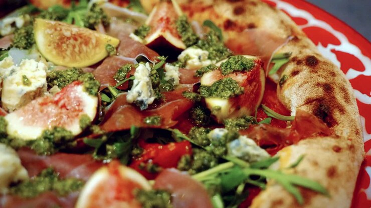 Autentico processo di preparazione della pizza in una pizzeria tradizionale italiana, con una pizza deliziosa e invitante in primo piano.