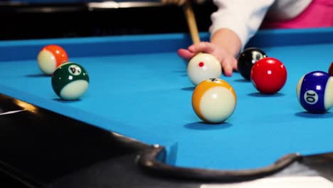 Playing-a-game-of-billiards-hitting-the-half-orange-ball-in-a-corner-pocket