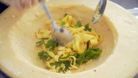 chef prepares pasta in cheese