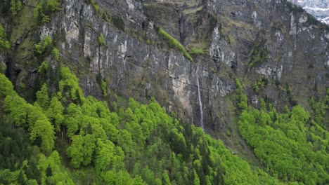 Majestic-waterfall-cascades-from-cliff-of-mountain-in-Switzerland,aerial