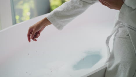 woman relaxing in a bubble bath with rose petals