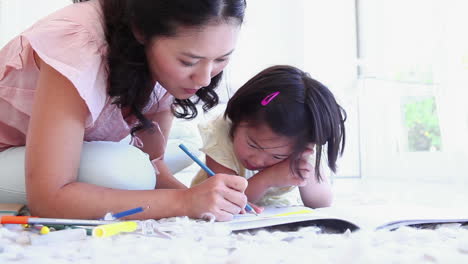 mother helping her daughter with colouring