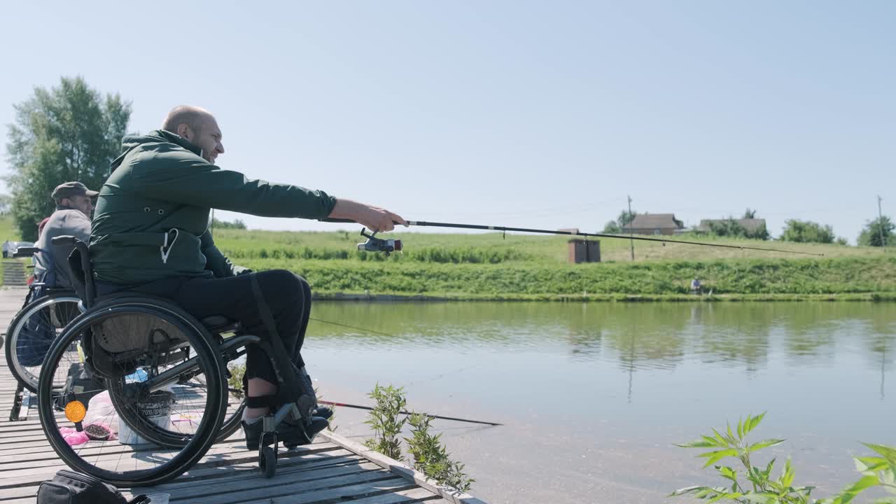 Man with disabilities fishing at a lake. Wheelchair. Summertime. Disabled person fishing