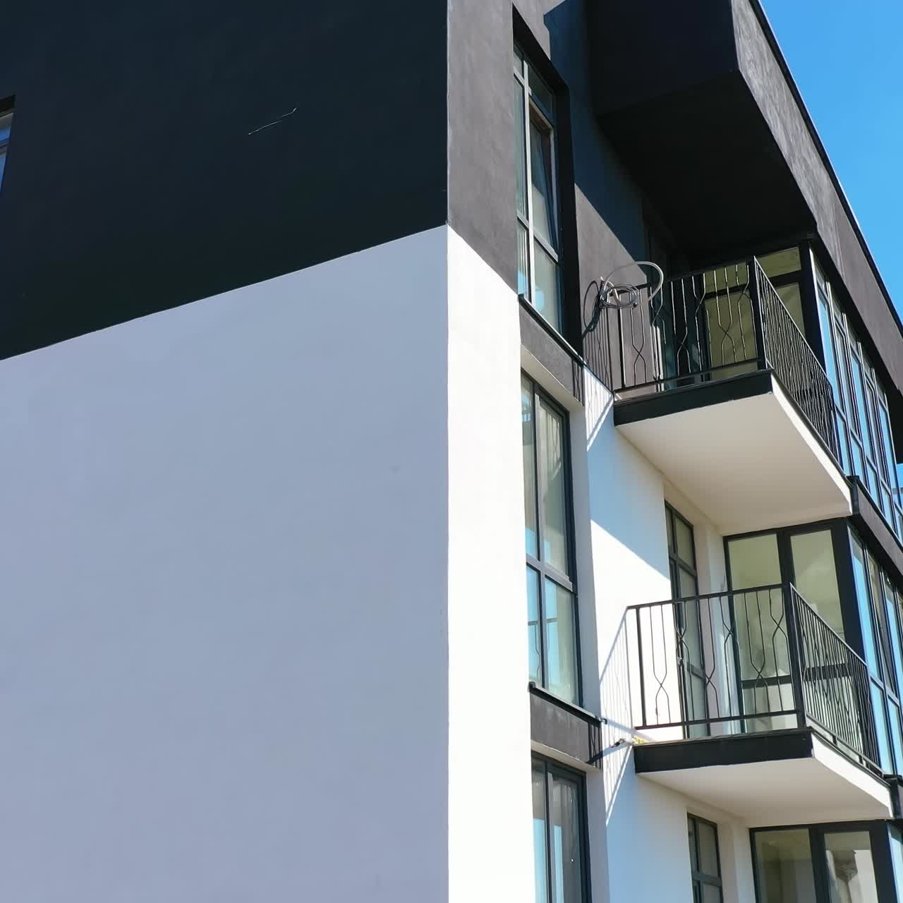 Nyopført facade på en moderne lejlighedsbygning. Eksteriør af en bygning med flere etager. Moderne design af urban arkitektur. Luftfoto