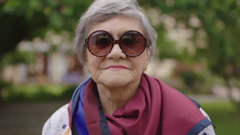 Nahaufnahme-Porträt-Einer-Fröhlichen-Alten-Frau,-Die-Glücklich-In-Die-Kamera-Lacht-Und-Eine-Sonnenbrille-Trägt