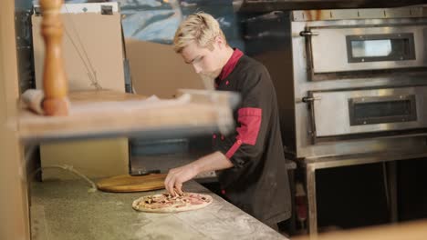 chef preparing pizza toppings in a restaurant kitchen