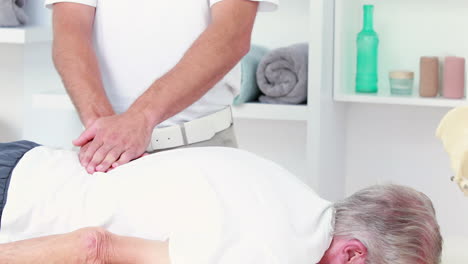 fisioterapeuta haciendo masaje de espalda a su paciente