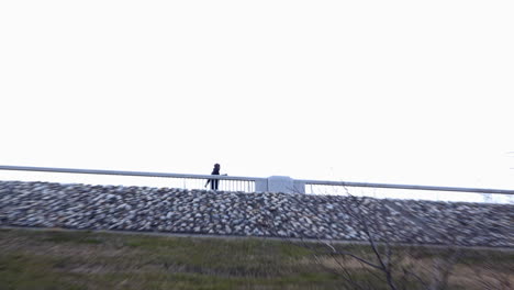 An-adult-male-walks-and-crosses-a-bridge