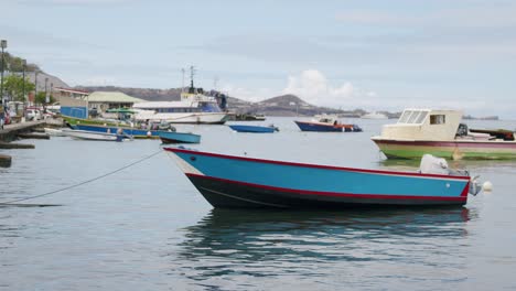 Barco-Pesquero-Azul-Se-Encuentra-En-Lo-Alto-Del-Agua,-Ya-Que-Está-Amarrado-A-La-Acera-En-La-Ensenada-De-Carenage-Granada