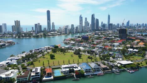 rising up to reveal the skyline of the iconic surfers paradise, magnificent high rise apartments, spakling reflections of gold coast main canal