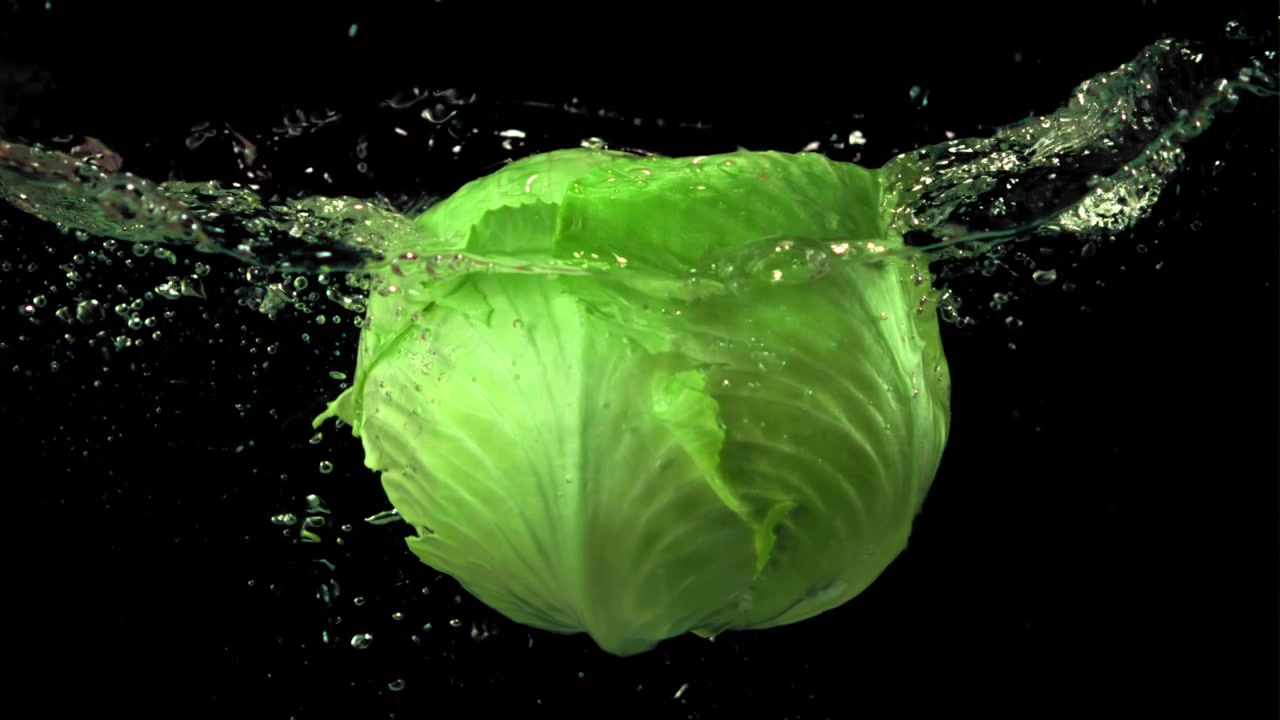 Fresh Green Cabbage Splashing in Water on Black Background