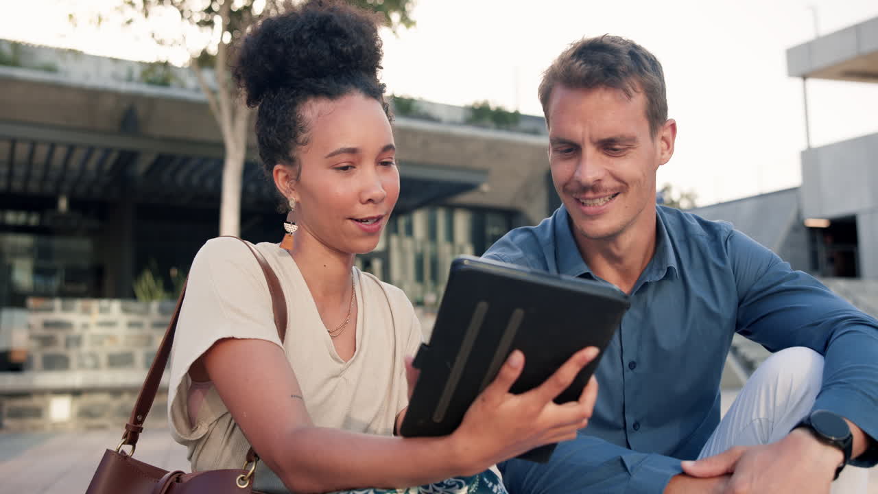 dos personas discutiendo en una tableta al aire libre