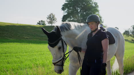 a-woman-is-walking-a-white-horse-in-nature