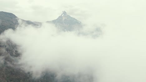 machapuchare peak (fishtail) surrounded by cloud ascending aerial