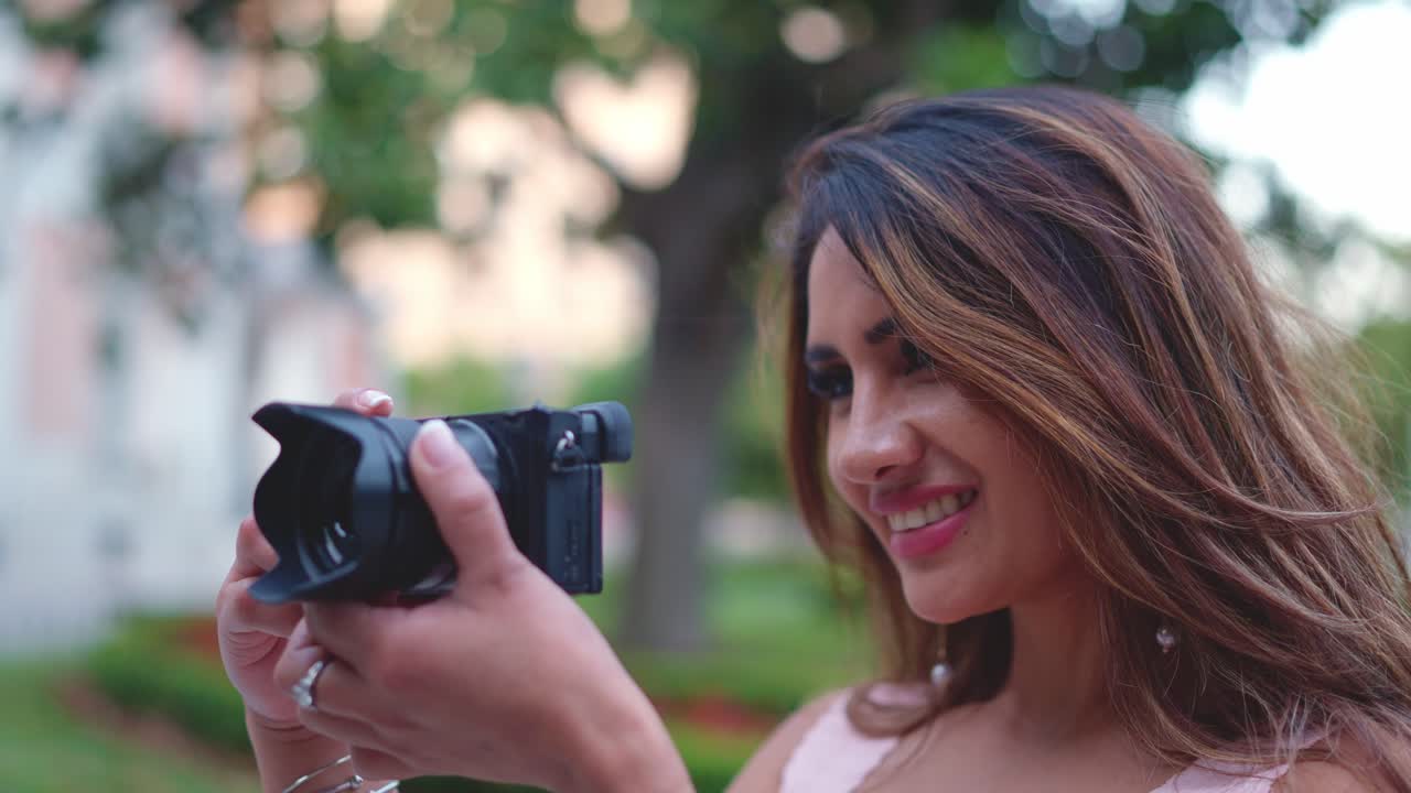 Mujer revisando fotos en una cámara al aire libre