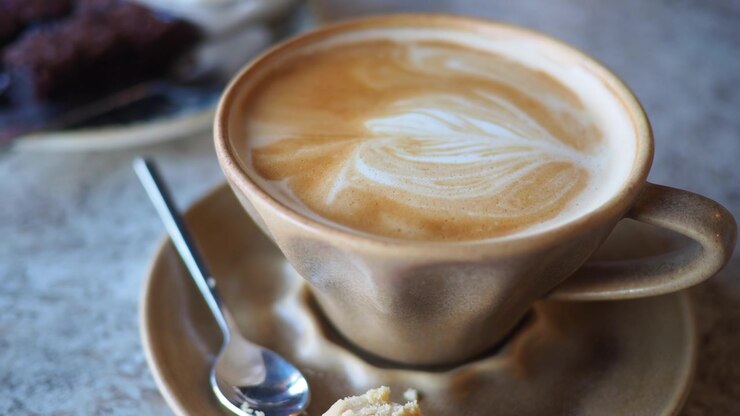 Primo piano di una tazza di caffè caldo con una bellissima latte art