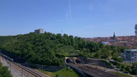 train leaves tunnel over bridge, tower