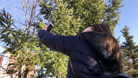 Cámara-Lenta-De-Una-Joven-Que-Se-Toma-Selfies-Con-Un-Smartphone-Usando-Una-Cámara-Frontal-En-Un-Parque-De-La-Ciudad