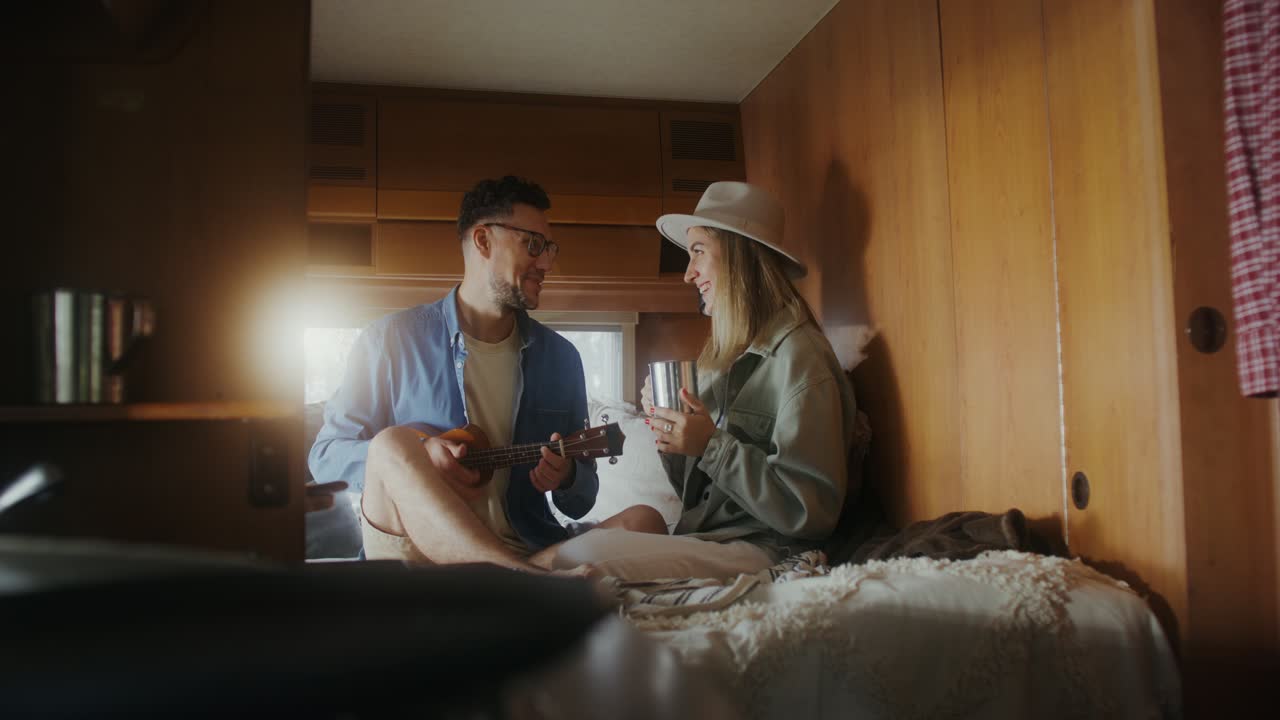 Couple enjoying coffee and music in their camper van