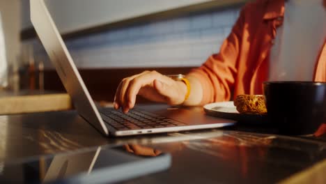 persona que trabaja en una computadora portátil con café y pasteles