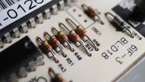 many resistors, chips and electronic components on an old retro circuit board controller with other electronic components