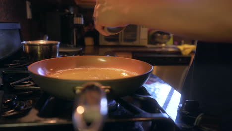 man grinding black pepper into pan of egg whites