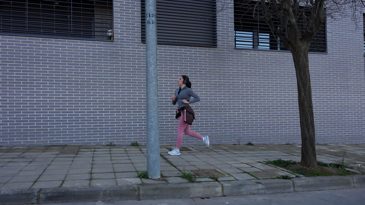 Female runner tracking her pulse on smartwatch during city run