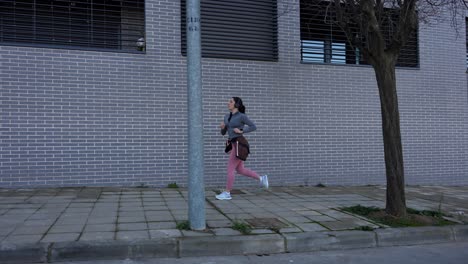 female runner tracking her pulse on smartwatch during city run