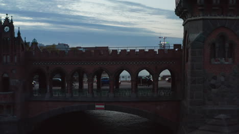 Langsame-Folgeaufnahme-Einer-Person,-Die-Durch-Den-Brückentunnel-Der-Berliner-Oberbaumbrücke-Geht,-Mittlere-Kamerafahrt-Aus-Der-Luft